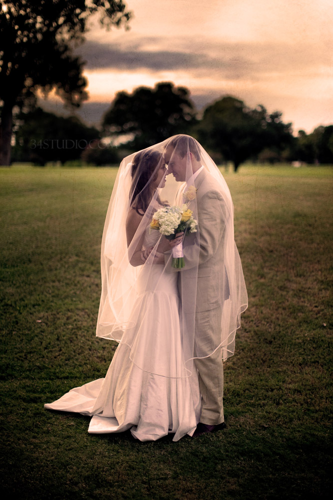 bride and groom under the veil making out